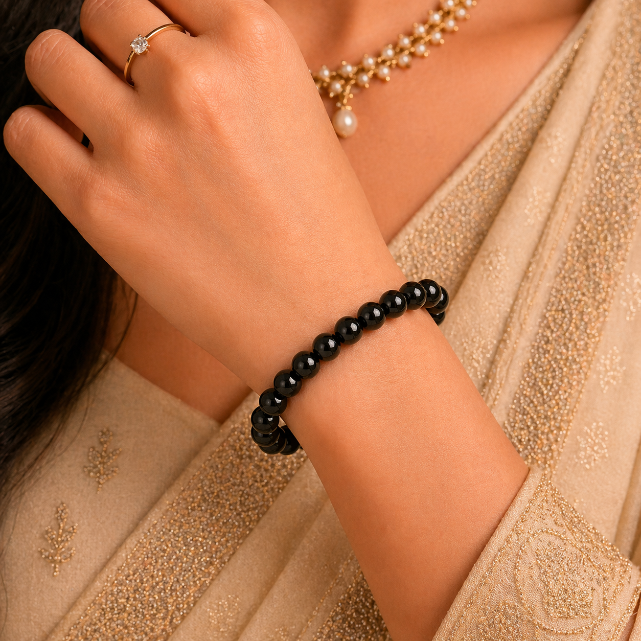 Close-up of a hand wearing a black tourmaline bracelet