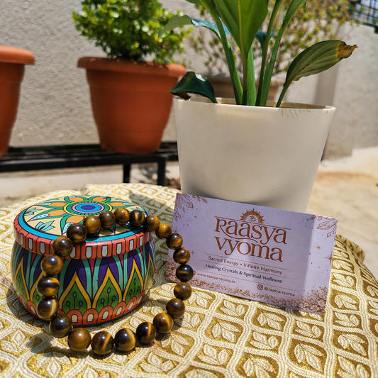 Decorative box with tiger bracelet and a card on a textured surface with plants in the background